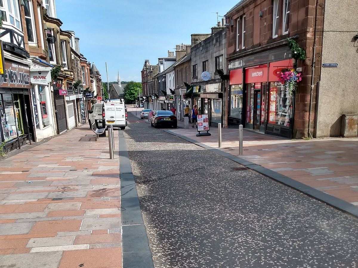 Carluke High Street, with paved pavements and local shops