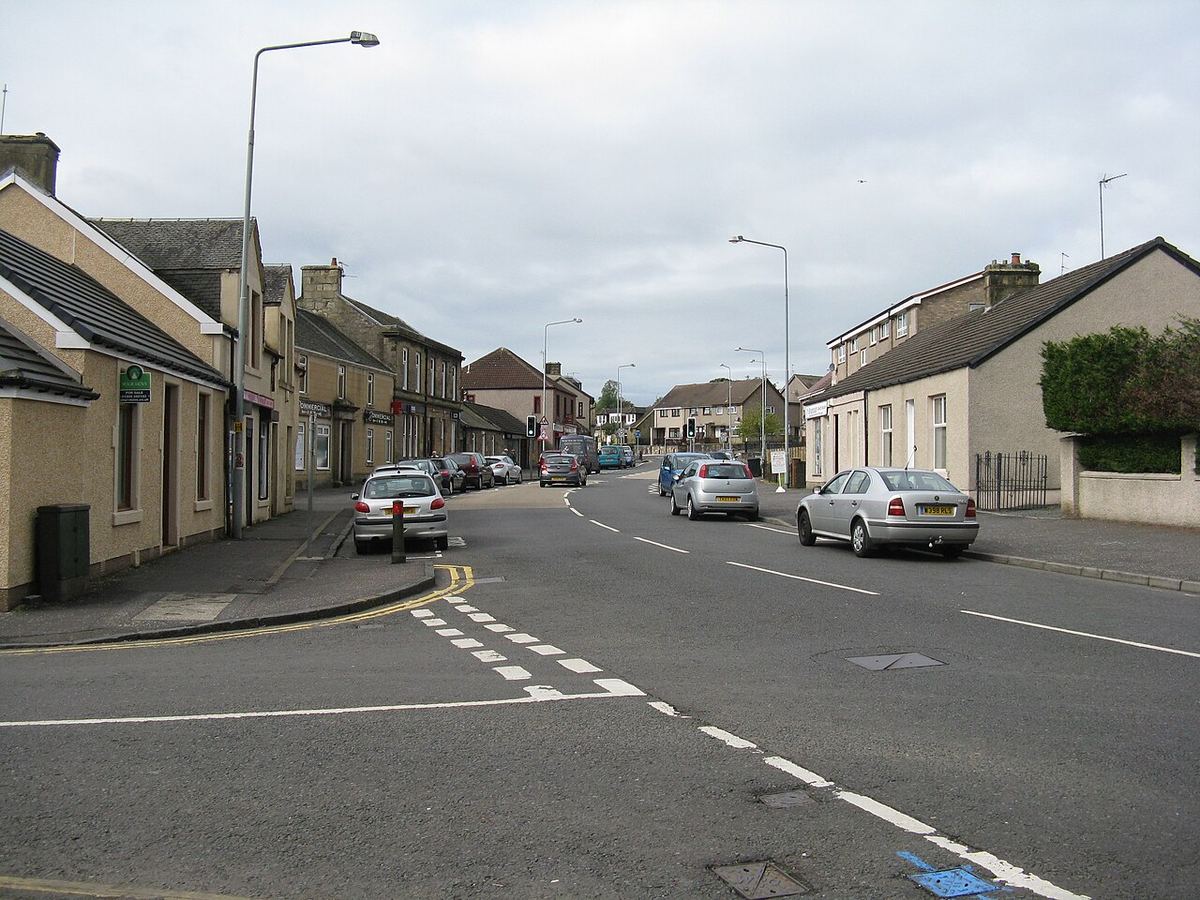 Main Street, Fauldhouse, with stone cottages and parked cars